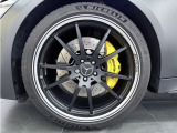 マットブラックペイント21インチAMG5ツインスポークアルミホイールの奥にはAMGダイナミックプラスパッケージを象徴するAMGイエローキャリパーが備わります。納車前に新品タイヤへの交換も別途承ります。