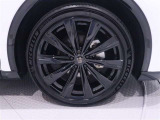 グロスブラック塗装の大径21インチ純正アルミホイールを装備しています。タイヤサイズは235/45R21です。