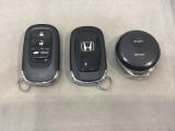 スマートキーを装備しています。鍵を差し込むことなくドアロックの開け閉めと、トランクが開けられる電動テールゲートのボタンもついています。加えて、純正リモコンエンジンスターター用の操作キーもついています。