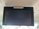 【フリップダウンモニター】後席用フリップダウンモニターを装備。天井から展開する大画面で、後席でも映像コンテンツを快適に楽しめます。ロングドライブ時の快適性を高める装備です。