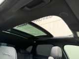 【電動パノラミックルーフ】車内に気持ちいい自然光が差し込み、頭上に広がる風景をお楽しみいただけます。快適な車内温度を維持し日差しから乗員とインテリアを守るダークカラーのガラス。電動ブラインド付き!