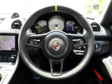 GT4 RS専用スポーツステアリングホイール。イエローのトップセンターマークが付いており、イエローでマーキングされたブラックのパドルシフトが、モータースポーツのように俊敏なギアシフトを可能にします。