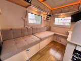 落ち着いたインテリアで、4人乗車が可能なファミリー対応レイアウトです。 簡単にベッド展開ができ、上部のバンクベッドとダイネットベッドを組み合わせて広い就寝スペースを確保できるのが特徴です。