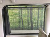 【ロールシェード】日差しや車外からの光が眩しいときにサッと引き出して使える、ロール格納タイプのサンシェードを装備。後席に乗ったお子様がウトウトしだした時など、ぜひご活用ください♪
