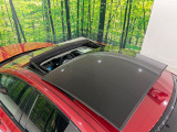 【電動パノラミックルーフ】車内に気持ちいい自然光が差し込み、頭上に広がる風景をお楽しみいただけます。快適な車内温度を維持し日差しから乗員とインテリアを守るダークカラーのガラス。