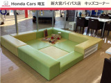 当店ショールーム入口の反対側からの風景です。ガラス張りの明るいショールームになっております。バリアフリーの床ですので、車いすでのご来店も可能です。ご家族様向けにキッズコーナーもご用意しております。