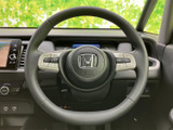 手元で握りやすい形状に、左右の操作スイッチを配置。運転中に視線を大きく移さず扱いやすく、必要な機能へ手元からアクセスできます。落ち着いた色合いで、運転席まわりにも自然になじむ仕立てです。