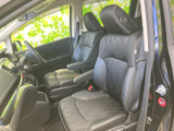 ゆったりとした前席は、シートの形状とひじ掛けがくつろぎやすさを支えます。運転席から前方を見渡しやすく、落ち着いた色合いの室内で、助手席の方も快適に過ごせる空間です。