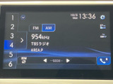 FM・AMの選択や受信中の放送局を画面で確認でき、ラジオを聴く際も操作内容が分かりやすい表示です。時刻も表示され、移動中の情報確認に役立ちます。