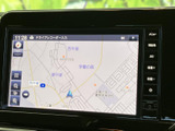 画面には現在地周辺の地図が表示され、道路や周辺施設を確認しながら目的地へ向かえます。タッチ画面の脇にはメニューや音量のボタンが並び、走行中も必要な表示を見つけやすい配置です。