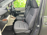 前席は視界が開けており、運転席と助手席の間も移動しやすい配置です。シートは落ち着いた色合いで、ドア側からも出入りしやすく、日常の乗車に便利な空間です。