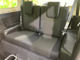 後席は左右に座席が並び、中央にも座面を備えたつくりです。窓から明るさが届き、座る方がくつろぎやすい落ち着いた色合いの室内。左右のシートベルトも確認でき、同乗者を迎える空間として活用できます。