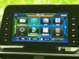画面には目的地や自宅、名称検索に加え、FM・AMやテレビ、Bluetooth Audioなどの項目が表示されています。メニューが整理され、移動中の目的に合わせて選びやすい構成です。