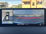 後方の映像に加えて車両周辺を俯瞰する表示もあり、駐車時の周囲確認を助けます。ガイド線を目安に後退でき、駐車スペースへの出し入れをサポートします。