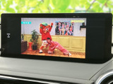 停車時にテレビ映像を楽しめる画面を備え、待ち時間を過ごす際にも活用できます。映像が画面内に表示され、メニュー操作も行いやすい配置で、車内での便利な装備です。