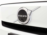 【ボルボの電気自動車を象徴するフロントフェイス】時代に合わせて変化するエンブレムデザイン。センターを斜めに大きく横切るラインと黒地に銀のアイアンマーク、これが最新ボルボのキャラクターアイコンです。