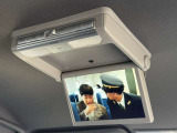 【フリップダウンモニター】後席用フリップダウンモニターを装備。天井から展開する大画面で、後席でも映像コンテンツを快適に楽しめます。ロングドライブ時の快適性を高める装備です。