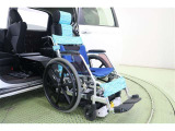 専用車いすをサイドアクセスユニットにセットし、固定装置のフックを掛け固定用ベルトで専用車いすの前輪を固定します。