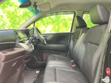 前席は視界が広く、運転席と助手席の間にもゆとりを感じる配置です。シートは身体を預けやすい形状で、黒を基調とした室内が落ち着いた雰囲気を演出。助手席の方にも快適にお過ごしいただける空間です。