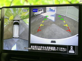 後方の映像に加えて周囲を俯瞰した表示も確認でき、駐車時の安全確認をサポートします。画面上のガイド表示を目安に、車両と周囲の位置関係を把握しやすい便利な装備です。