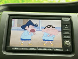停車中にテレビ映像を視聴でき、待ち時間などに車内で過ごす際の楽しみが広がります。画面には番組映像が表示されており、休憩中のひとときをゆったり過ごしたい方にも便利な装備です。