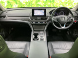 前席は運転席と助手席が並び、中央のアームレストや収納スペースも手の届きやすい位置にあります。落ち着いた色合いの室内で、運転席から前方を見渡しやすい印象です。
