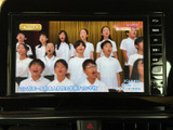 テレビ番組を画面で視聴でき、停車中の休憩時間などに映像を楽しめます。画面には番組映像や字幕が表示されており、車内で過ごす時間の過ごし方が広がる装備です。