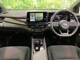 運転席まわりは前方の見通しがよく、画面やメーター類も目に入りやすい配置です。シートには赤い差し色が施され、運転席・助手席ともに落ち着いて座れる雰囲気が広がります。