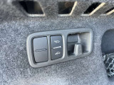 トランク内左側にボタンがございます。ボタン1つでリアシートの操作、車高調整可能です。荷物の出し入れに有効活用できます。
