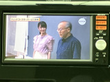 画面にはテレビ番組の映像が表示され、停車中のひとときに映像を視聴できます。画面脇には選択ボタンや音量調整部も備わり、必要な項目を確認しながら使える構成です。
