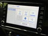 オーディオソース選択画面にはAM・FMやBluetoothなどが並び、用途に合わせて選びやすい構成です。画面の周囲に操作ボタンが配置され、日常の移動中にも確認しやすく便利です。