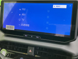 大きく見やすい画面にラジオやテレビ、交通情報などの項目が並び、必要なメニューを確認しやすい構成です。画面下には音量調整部も備わり、運転中の情報確認や日常のエンタメ利用に役立ちます。