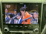 停車中にテレビ番組を視聴でき、待ち時間も車内で過ごしやすくなります。画面には番組映像が表示され、周囲に操作ボタンもまとまっているため、扱いやすい構成です。