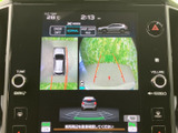 後方の映像に加えて車両周辺を確認できる画面表示があり、駐車時の周囲確認をサポートします。画面には目安となるラインも表示され、切り返しや駐車位置を確認する際に便利です。