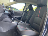 運転席と助手席には、赤いアクセントが映える黒基調のシートを採用しています。前方や左右の窓から光が入り、室内を見渡しやすい印象。落ち着いた雰囲気でお過ごしいただけます。