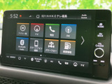 画面にはナビや電話、FM、Bluetoothオーディオなどのメニューが並び、目的に応じて選びやすい表示です。物理ボタンや音量つまみも備わり、操作箇所を把握しやすい構成です。