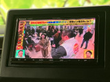 停車中にテレビ映像を視聴でき、休憩時間や待ち時間を車内で過ごす際に活躍します。画面に番組映像が表示され、音楽以外の楽しみ方も選べる便利な装備です。