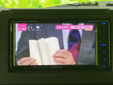 画面にはテレビ番組が表示され、停車中のひとときに映像を楽しめます。中央に配置されており、画面表示を確認しやすいのも便利なポイントです。日常の車内で活用いただけます。