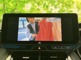 停車中にテレビ番組を視聴でき、休憩時間も車内でゆったり過ごせます。画面に映像が表示され、音量調整などのボタンも手元で確認しやすい配置です。
