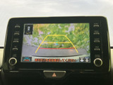 車両後方の映像とガイド線をモニターで確認でき、駐車時の後方確認をサポートします。周囲を直接確認する注意表示もあり、駐車場での操作に役立つ装備です。
