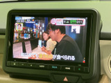 テレビ番組を画面に表示でき、停車中の待ち時間などに映像を楽しめます。画面は大きく見やすく、ナビやオーディオの操作ボタンも下部にまとまっています。日常にうれしい装備です。