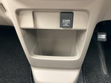 足元近くには小物を置ける収納スペースがあり、車内で使う品をまとめておけます。上部には電源コンセントの表示も確認でき、日常の移動中に役立つ装備が集まっています。