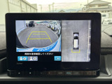 後方映像に加えて車両周囲を俯瞰した表示も確認でき、駐車時の周囲確認をサポートします。画面上のガイド表示もあり、車庫入れや切り返しの際に役立ちます。