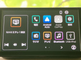 画面には電話や地図、ラジオ、テレビ、音楽などのメニューが並び、目的の機能を選びやすい表示です。スマートフォン連携や設定項目も確認でき、日々の移動を便利にサポートします。