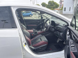 運転席まわりは視界が広く、前方や左右を確認しやすいレイアウトです。シートとドアに配された赤のアクセントが印象的で、落ち着いた色合いの室内に彩りを添えます。
