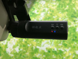フロントガラス上部に取り付けられた小型の記録機器です。録画状態を示す表示やボタンが本体に備わり、運転中の状況を記録する装備として日常の運転をサポートします。