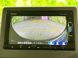 後方の様子を画面で確認しながら駐車でき、黄色いガイドラインが車庫入れの目安になります。周囲を直接確認する操作も案内されており、駐車時の安全確認をサポートしてくれます。