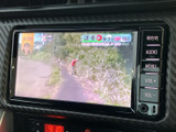 画面には映像が表示され、周囲には現在地やメニュー、音量のボタンが並びます。停車中に映像を楽しみたいときにも、画面を見ながら操作しやすい配置です。