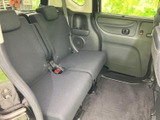 後席には左右それぞれのシートが備わり、中央席を含めて乗員が過ごしやすい空間です。足元にもゆとりがあり、ドア側には収納スペースも見られます。落ち着いた色合いで、同乗者もくつろいで過ごせます。