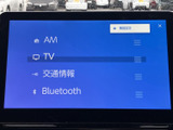 AMやテレビ、交通情報、Bluetoothなどの項目が一覧で表示され、使いたい機能を選びやすい画面です。文字とアイコンが見分けやすく、目的のメニューを確認しやすい構成です。
